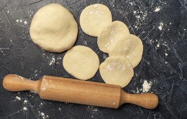 ball of fresh raw dough, flour and rolling pin top view