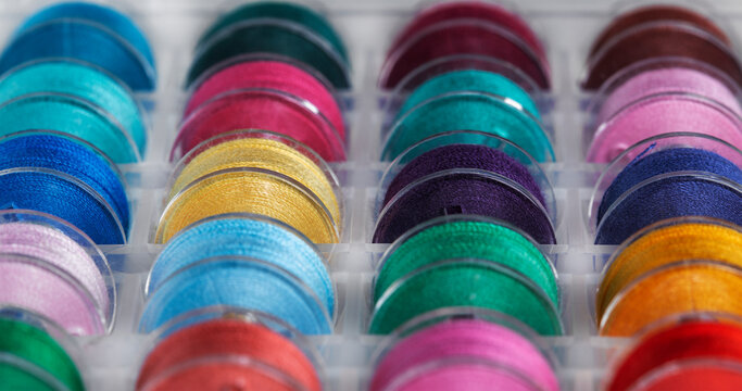 Plastic bobbins for a sewing machine with multi-colored threads.