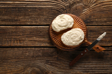 Board of tasty sandwiches with cream cheese on wooden background