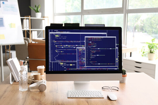 Computer monitor with programming code at programmer's workplace in office
