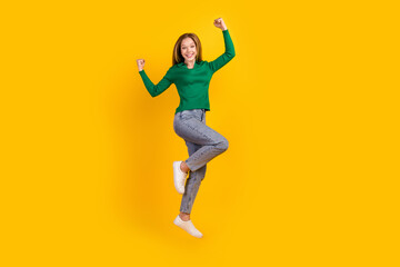 Fototapeta na wymiar Full length photo of achievement teenager girl celebrate her winnings in competition jumping higher isolated on yellow color background