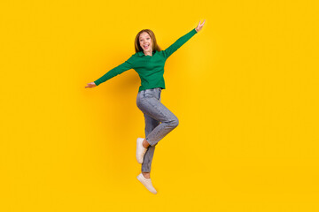 Full length body photo of energetic teenage girl have fun flying in air with hands like bird wings...
