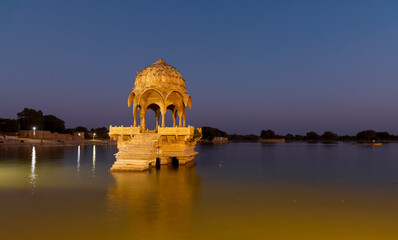 Historic Chhatri, an elevated dome pavilion in Gadisar lake, Rajasthan, India shot during twilight.