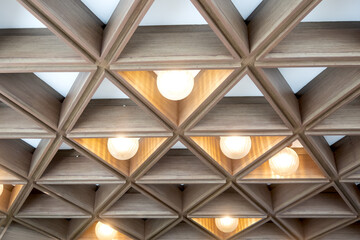 Lamps on the ceiling in the middle of triangular wooden pattern,