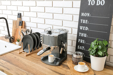 Modern coffee machine with cup of hot espresso on table in kitchen - obrazy, fototapety, plakaty