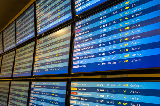 Digital boards showing International flight departure information at CDG Airport in Paris, France.