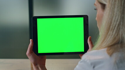 Closeup lady watching greenscreen tablet at office. Woman hands holding computer