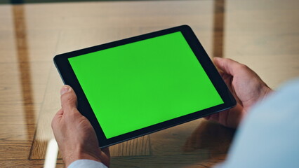 Man hand touching green tablet screen indoor closeup. Manager using computer