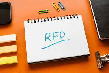 There is notebook with the word RFP. It is an abbreviation for Request For Proposal as eye-catching...