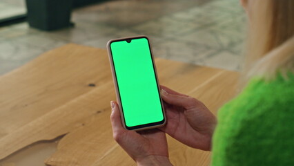 Woman hands hold chromakey phone in office closeup. Unknown lady reading news