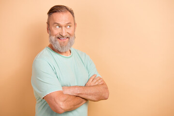 Portrait of impressed man with gray beard wear stylish t-shirt arms folded look at offer empty space isolated on pastel color background
