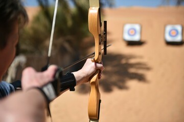 Woman doing archery in the desert of Dubai, United Arab Emirates, Asia