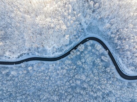 Winding country road near Gutenberg on the Swabian Alb in winter, there is snow in the forest, drone photo, Lenningen, Baden-Wuerttemberg, Germany, Europe