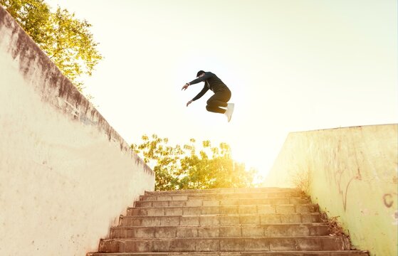 Man doing parkour jumping walls. Latin man doing parkour jumping walls, Low angle of man doing parkour at sunset