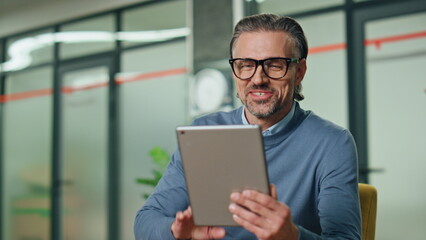 Smiling man greeting video chat in office closeup. Happy director waving hand