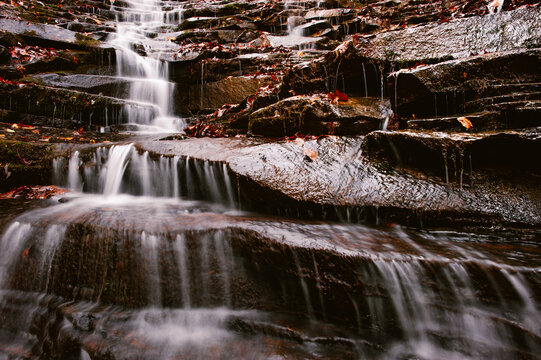 A waterfall cascades down dark rock along the Cumberland Trail in Rock Creek Gorge, Tennessee