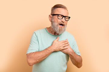 Photo of upset depressed retired man wear arms chest having heart attack isolated on beige color background