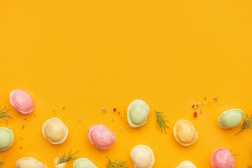Colorful raw dumplings with spices and dill on orange background