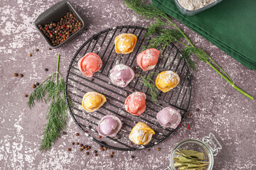 Fototapeta na wymiar Stand of colorful raw dumplings with peppercorn and dill on dark background