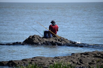 Hombre pescando en la orilla del río