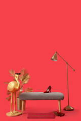 Grey bench, flamingo statue and standard lamp on red background