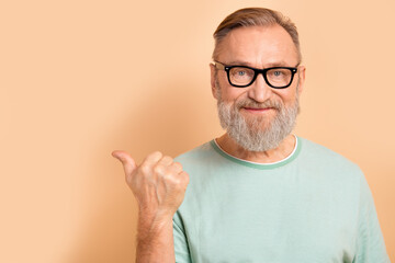 Portrait of pleasant smart senior man in glasses wear stylish t-shirt indicating at offer empty...