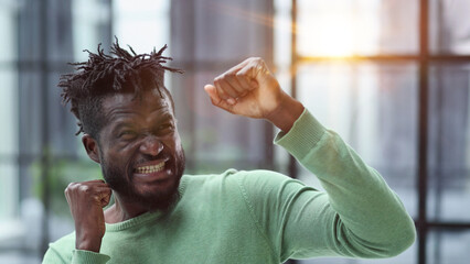 African man rejoices at the victory with his hands up