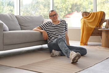 Young man sitting on floor at home