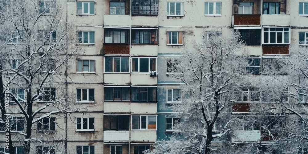 Aufkleber A picture of a tall building with numerous windows covered in snow. This image can be used to depict winter, architecture, urban landscapes, or the beauty of a snowy day