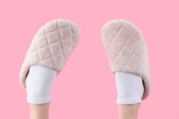 Female legs in soft slippers on pink background