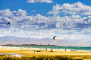 Kite surfers riding waves. Kiteboarding sport. Tarifa Spain.
