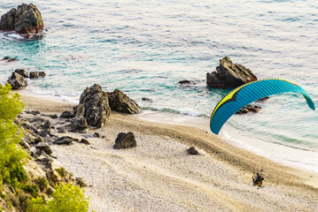 Paraglider flying over sea shore