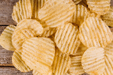 Top view of potato chips on wooden background