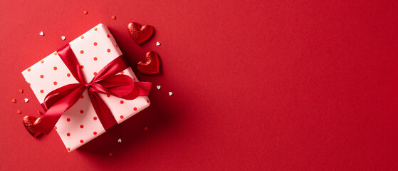 Valentine's day gift. Banner design with present box and hearts on red background.