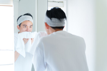 タオルで顔を拭く男性
