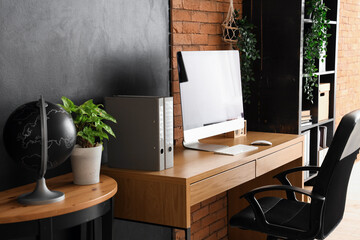 Blank computer monitor with folders on table in modern office
