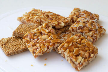 Peanut chikki and Til chikki on white background. peanut chikki and til chikki are an Indian sweet dishes made with jaggery, peanut and sesame. Indian festival Makar Sankranti special sweet.