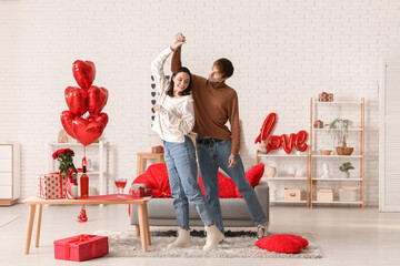 Young couple dancing at home. Valentine's day celebration - obrazy, fototapety, plakaty
