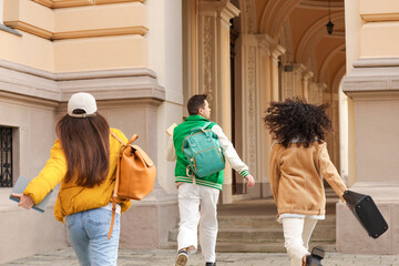 Being late. Group of students running towards building outdoors, back view