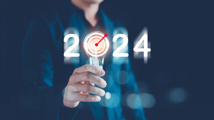 Business target and goals trends 2024, Analytical Businessman holding light bulb with planning business growth 2024, New business start up, technical analysis strategy, strategy digital marketing.