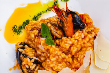 Risotto with seafood and parmesan cheese on white plate.