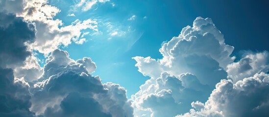 Graceful clouds churn in the vast blue sky. - obrazy, fototapety, plakaty