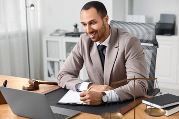 Naklejka premium Smiling lawyer working at table in office