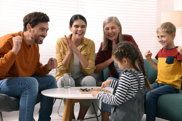 Family playing checkers at coffee table in room