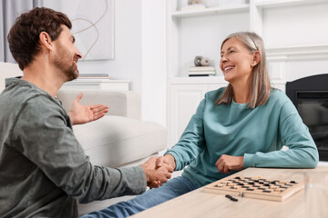 Obraz premium Checkers. Players shaking hands after game at home