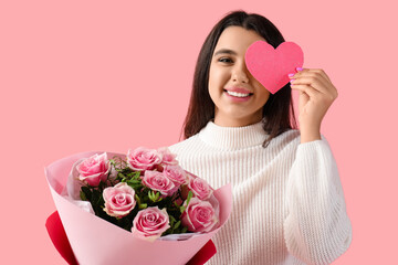 Funny young woman with bouquet of roses and paper heart for Valentine's day on pink background