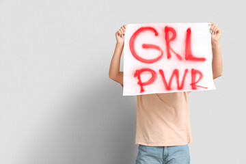 Woman covering face with sign GRL PWR on white background. Feminism concept