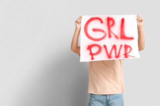 Woman covering face with sign GRL PWR on white background. Feminism concept