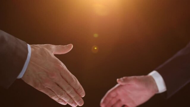 The men shake hands. Shaking hands after making a profit on a black background