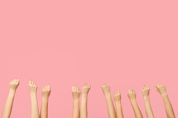 Female hands with clenched fists on pink background. Women history month
